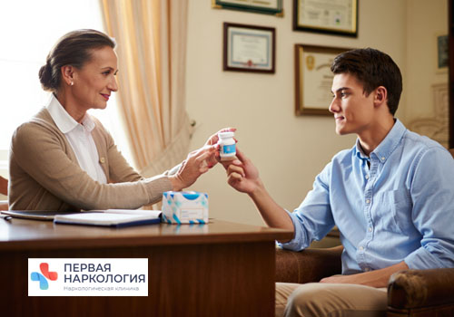 Психотерапевт дает пациенту баночку с лекарством